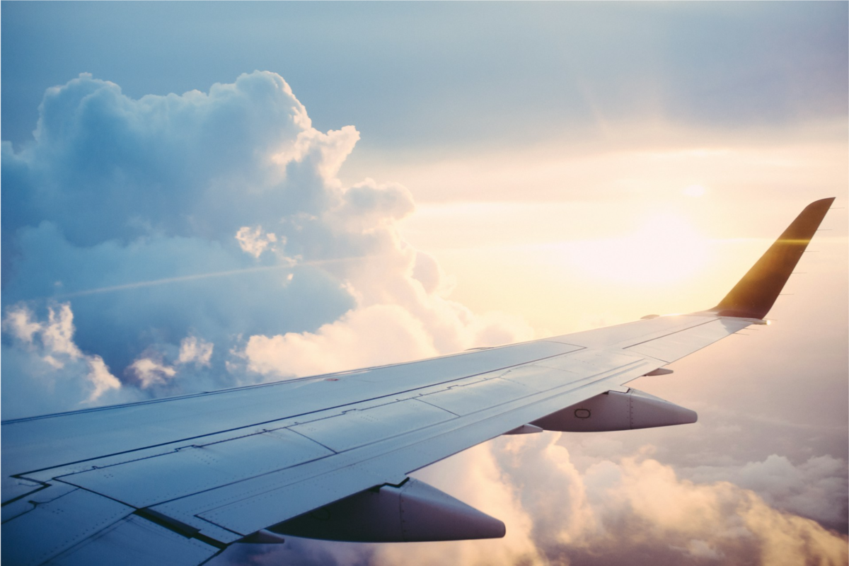 A close-up of an airplane wing in the sky. 