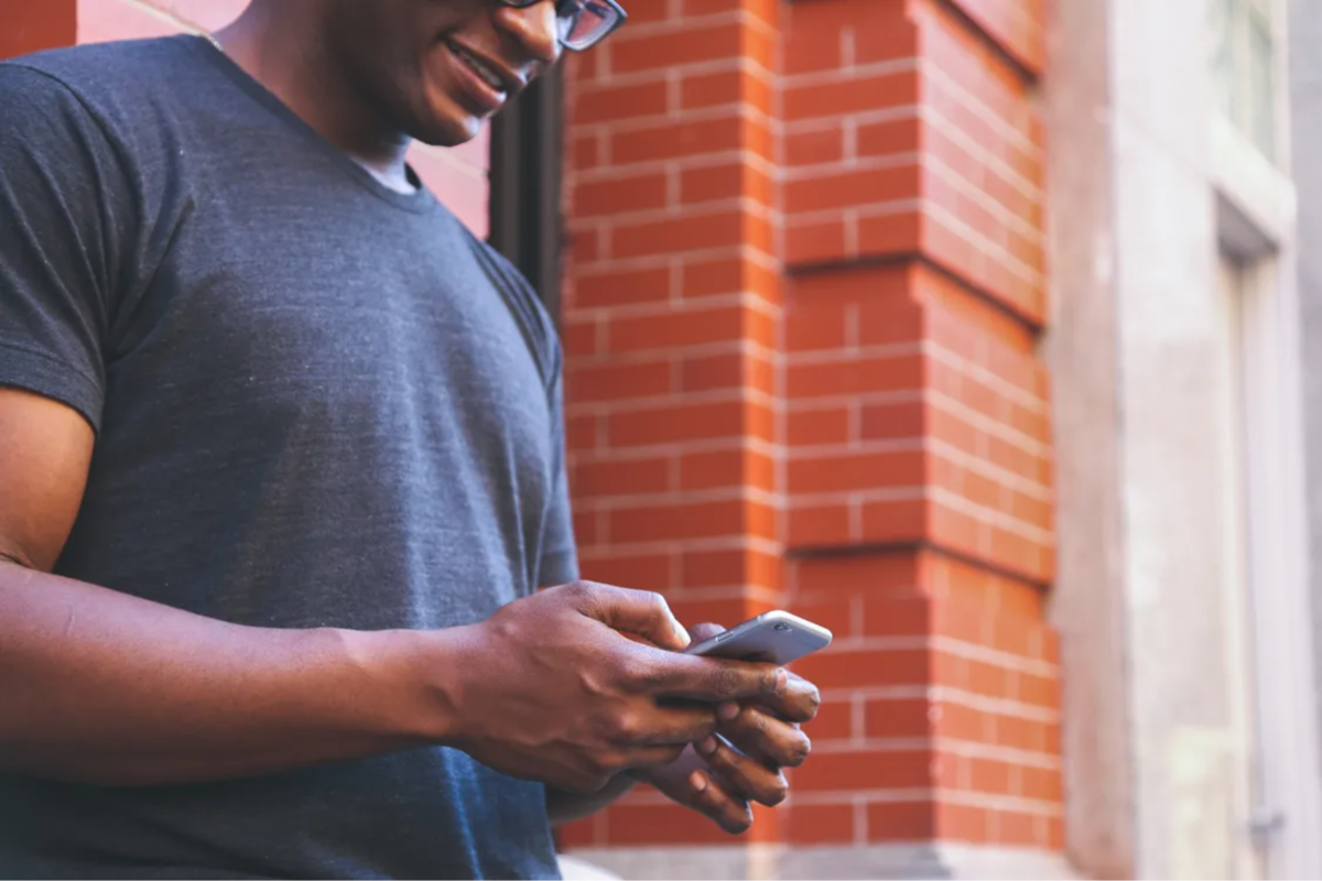 A close-up of a person holding a cell phone, ready to type a text message.