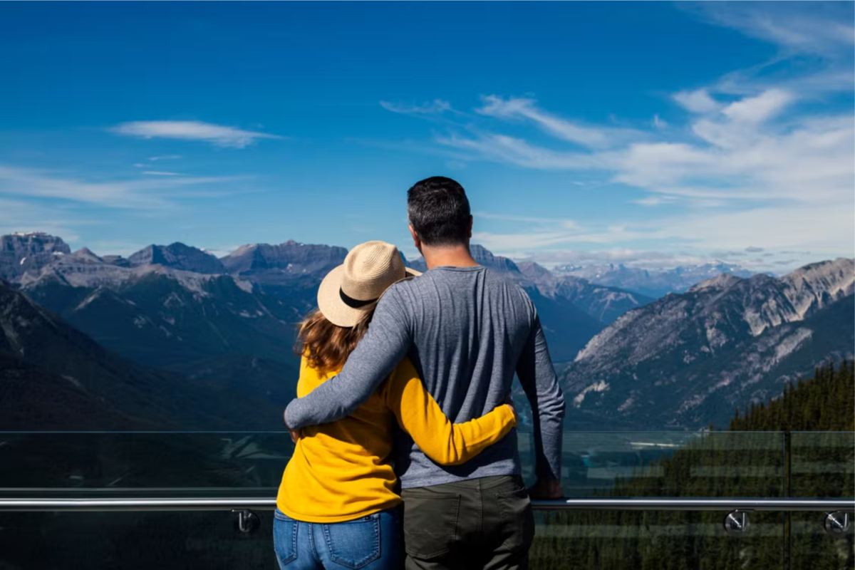 A couple embraces while looking out at the mountains in Banff, Alberta.